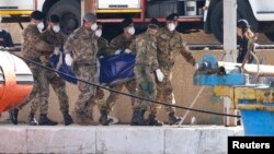 Soldiers carry the body of a victim of a shipwreck off Sicily in Lampedusa harbor October 6, 2013.