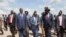 Le président du Soudan du Sud Salva Kiir (C/R) marche avec des responsables sur le tarmac de l'aéroport international de Juba le 13 septembre 2018, après son retour de la capitale éthiopienne Addis-Abeba.