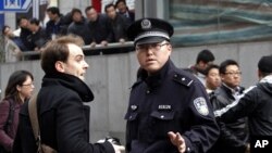 Policeman asks foreign journalist to leave area near Peace Cinema, after calls for a "Jasmine Revolution" protest, organized through internet, in downtown Shanghai, February 27, 2011