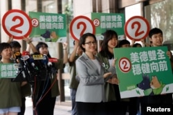 Hsiao Bi-khim, vice president candidate for the ruling Democratic Progressive Party (DPP), poses for the media holding a banner outside the Central Election Commission in Taipei.(REUTERS/Carlos Garcia Rawlins)