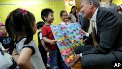 Students welcome New York Mayor Bill de Blasio to their pre-kindergarten class at the Brooklyn Chinese American Association Early Childhood Education Center, May 27, 2014, in New York. 