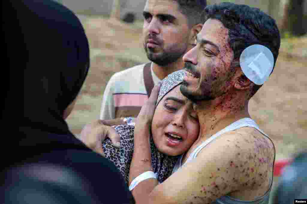 A Palestinian man named Ramadan Al-Zard, who was wounded in an Israeli strike that killed his relatives, hugs his niece who was also injured, amid the Israel-Hamas conflict, in Khan Younis in the southern Gaza Strip.