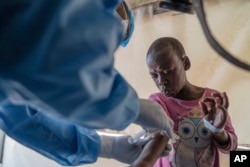 FILE - A health worker attends to a mpox patient, at a treatment center in Munigi, eastern Congo, Aug. 19, 2024. (AP Photo/Moses Sawasawa, file )