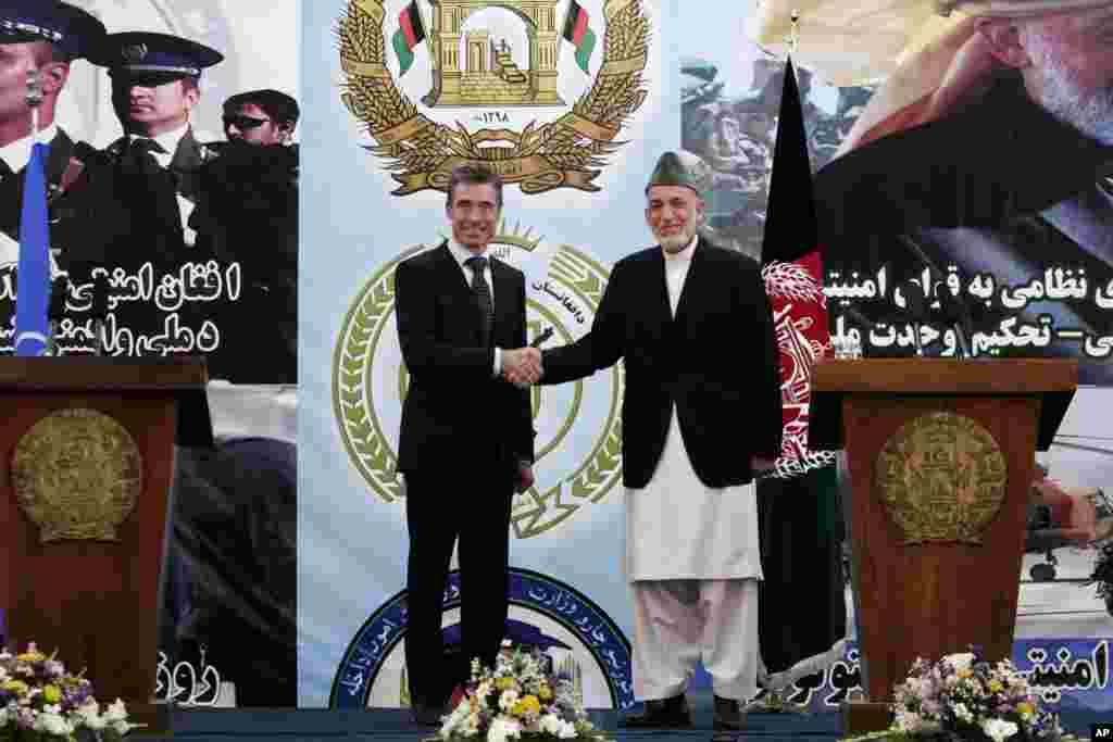 Afghan President Hamid Karzai shakes hands with NATO Secretary-General Anders Fogh Rasmussen after a ceremony at a military academy on the outskirts of Kabul, Tuesday, June 18, 2013.