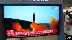 2026년 10월 3일 한국 서울역에서 열차 이용객들이 북한의 미사일 발사 관련 뉴스 프로그램 속 자료 화면을 TV 화면으로 지켜보고 있다.