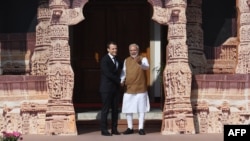 Indian Prime Minister Narendra Modi (R) welcomes French President Emmanuel Macron to the founding conference of the International Solar Alliance in New Delhi on March 11, 2018. 