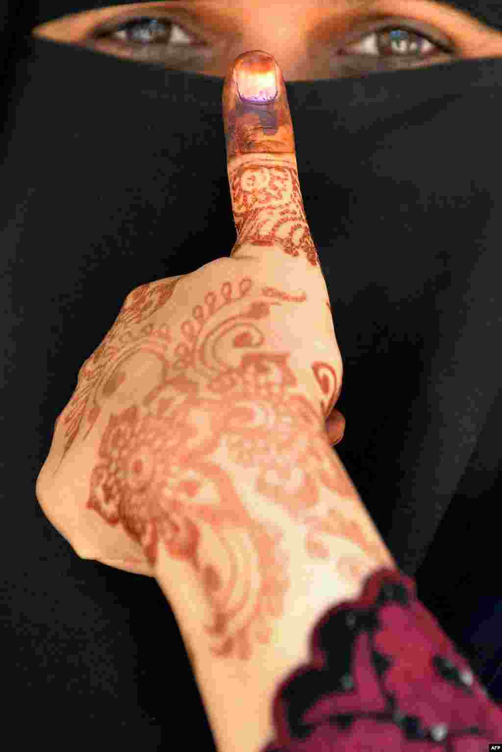 An Indian Muslim woman displays her inked thumb after casting her vote at a polling station in Bangalore.