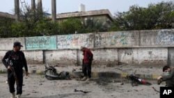 Sejumlah petugas kepolisian memeriksa lokasi pengeboman di pinggiran Peshawar, Pakistan, pada 10 Maret 2024. (Foto: AP)