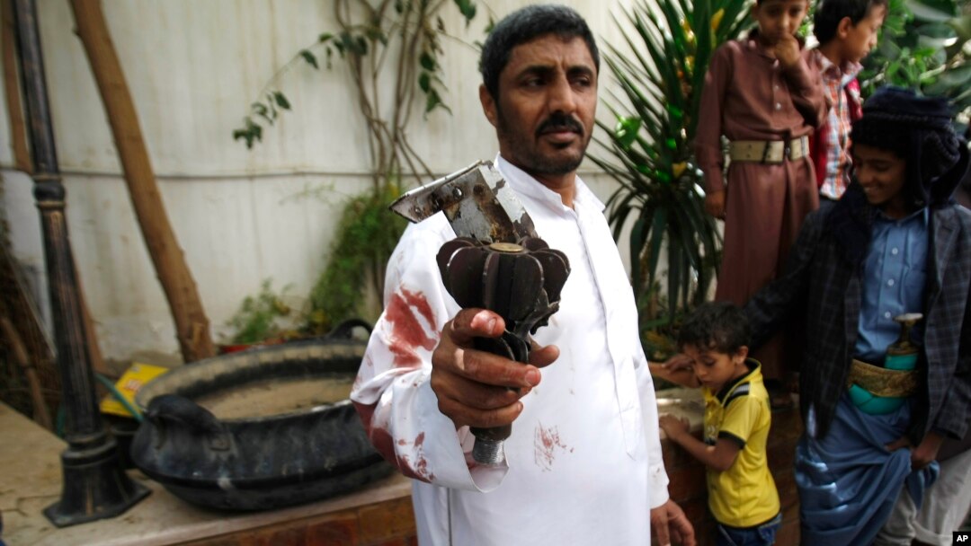 A Houthi Shiite rebel holds part of a projectile launched by Yemeni forces during clashes between Yemeni forces and Houthi militants in Sanaa, Yemen, Sept. 19, 2014. 