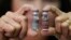 A Manila Health officer shows off a pair of vials of the anti-dengue vaccine Dengvaxia after being recalled from local government health centers Tuesday, Dec. 5, 2017 in Manila, Philippines. The World Health Organization says the first-ever vaccine for dengue needs to be dealt with in "a much safer way," meaning that the shot should mostly be given to people who have previously been infected with the disease.