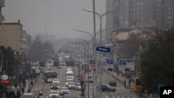 FILE - Traffic moves along Bill Clinton Boulevard during smog and heavy air pollution in Kosovo capital Pristina, Dec. 20, 2019. 