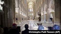 French President Emmanuel Macron, center left, and his wife Brigitte Macron, third right, visit the restored interiors of Notre-Dame Cathedral, Friday, Nov.29, 2024 in Paris. (Christophe Petit Tesson, Pool via AP)