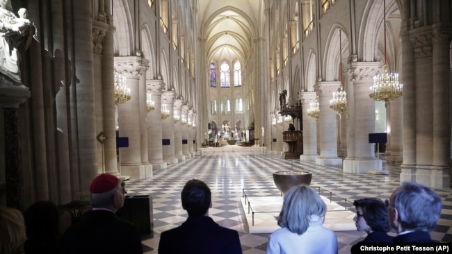 French President Emmanuel Macron, center left, and his wife Brigitte Macron, third right, visit the restored interiors of Notre-Dame Cathedral, Friday, Nov.29, 2024 in Paris. (Christophe Petit Tesson, Pool via AP)