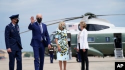 President Joe Biden waves as he and first lady Jill Biden walk to board Air Force One for a trip to Georgia to mark his 100th day in office, April 29, 2021, in Andrews Air Force Base, Md.