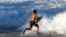 A bodeyboarder runs into the waves at Waimea Bay after the Memory of Eddie Aikau surfing contest was canceled, Feb. 10, 2016, in Haleiwa, Hawaii. 
