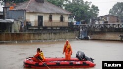 A rescue team set up a line across the swollen Ciliwung river in Jakarta, Indonesia, Feb. 5, 2018.