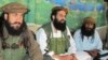 FILE - Pakistani Taliban spokesman Shahidullah Shahid (C), flanked by bodyguards, is seen talking to reporters at an undisclosed location in Pakistani tribal area of Waziristan, Oct. 5, 2013.