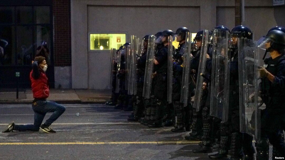 Čovek na kolenima ispred kordona policije u Sent Luisu, u Misuriju (Foto: Reuters/Lawrence Bryant)