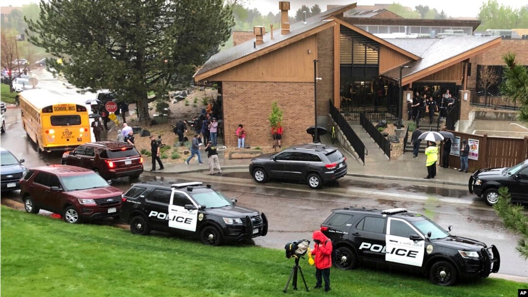 Police and others are seen outside a recreation center where students are reunited with their parents, in the Denver suburb of Highlands Ranch, Colo., after a shooting at STEM School Highlands Ranch, May 8, 2019.