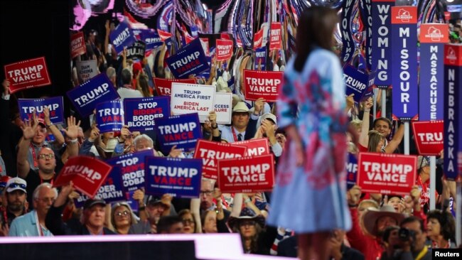 Asistentes sostienen carteles en apoyo al expresidente Donald Trump y su compañero de fórmula presidencial, J.D. Vance, mientras la ex embajadora de EEUU ante la ONU, Nikki Haley, habla en la Convención Nacional Republicana, en Milwaukee, Wisconsin, 16 de julio de 2024