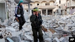 FILE - Kurdish female fighters move to another secured point in the contested zone of Kobani, Syria, on Nov. 19, 2014. 