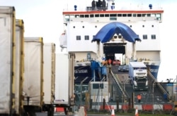 FILE - Lorries and cars disembark from a ferry arriving from Scotland at the P&O ferry terminal in the port at Larne on the north coast of Northern Ireland, Jan. 1, 2021.