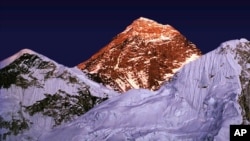 FILE - A golden glow is cast as the sun sets on the worlds highest mountain, center, seen from Kalapathar, on the trail to Everest, Nepal, Tuesday Nov. 15, 1983. (AP Photo/Bikas Das)