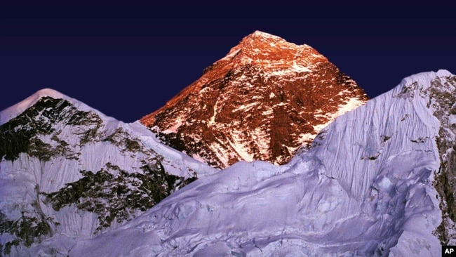FILE - A golden glow is cast as the sun sets on the worlds highest mountain, center, seen from Kalapathar, on the trail to Everest, Nepal, Tuesday Nov. 15, 1983. (AP Photo/Bikas Das)