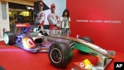 Promotions for the first ever Indian Formula One race are taking place across the country. A model stands next to a Formula One replica at a mall in Ahmedabad, Oct. 17, 2011.