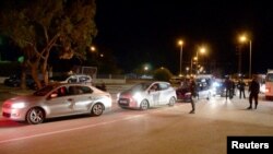 Anggota pasukan keamanan membantu jemaah haji pergi dengan mobil mereka, menyusul serangan di dekat sinagog, di Djerba, Tunisia 9 Mei 2023. (Foto: Reuters)