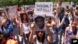 星期六在美国步枪协会年会会场外要求严格控制枪支的示威者为枪下丧生者举行默哀