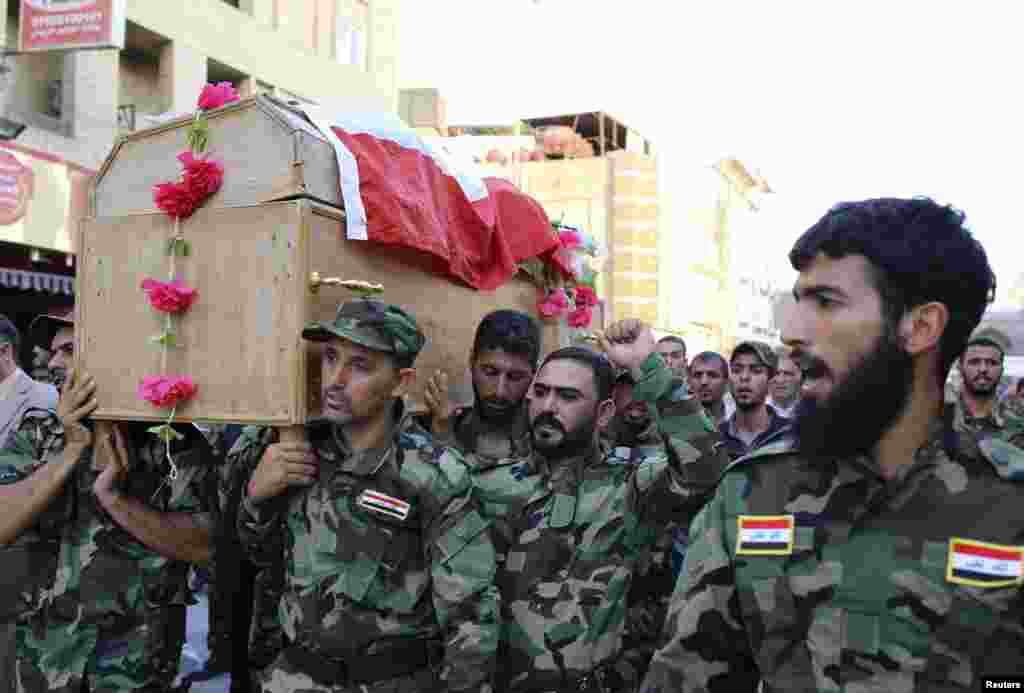 Mourners carry the coffin of a Shi'ite volunteer from the brigades of peace, who joined the Iraqi army and was killed during clashes with militants in Samarra, during his funeral in Najaf, Iraq, July 6, 2014.