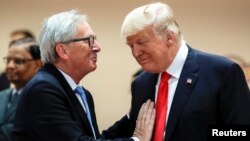 Presiden AS Donald Trump (kanan) berbincang dengan Presiden Komisi Eropa Jean-Claude Juncker (kiri), sebelum sesi di KTT G-20 di Hamburg, Jerman, 8 Juli 2018.