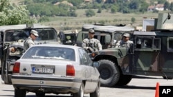 US soldiers serving in KFOR check vehicles from Serbia entering Kosovo after reopening a checkpoint in this July 2011 file photo. Serbia and Kosovo recently came to agreement on managing their joint border crossings.