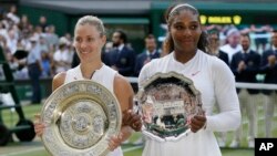 Angelique Kerber of Germany holds the winner's trophy after defeating Serena Williams of the United States, right, in the women's singles final match at the Wimbledon Tennis Championships, in London, July 14, 2018.