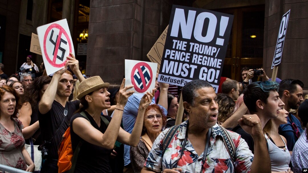 Demonstran meneriakkan slogan di depan Trump Tower menjelang kunjungan Presiden Donald Trump ke gedung kediamannya di New York, 14 Agustus 2017.