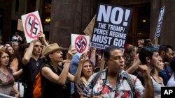 Demonstran meneriakkan slogan di depan Trump Tower menjelang kunjungan Presiden Donald Trump ke gedung kediamannya di New York, 14 Agustus 2017.