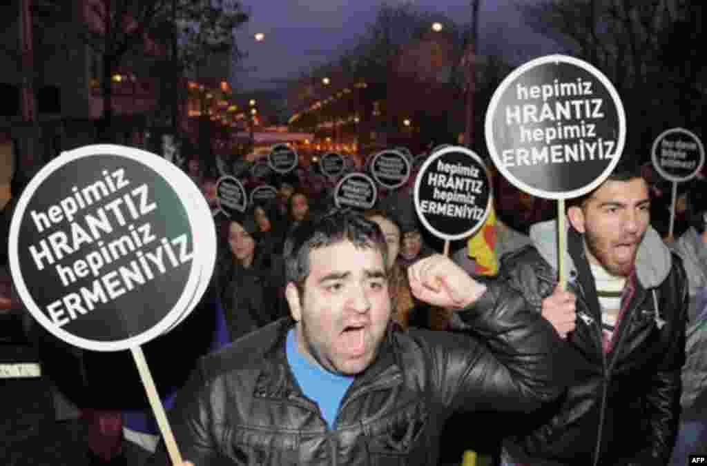 Hundreds of protesters hold placards that read 'We are all Armenians' as they shout slogans outside a courthouse in Istanbul, Turkey, Tuesday, Jan. 17, 2012. A Turkish court on Tuesday sentenced a man to life in prison for masterminding the killing of an 