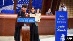 این عکس که روز دوشنبه ۶ شهریور ۱۴۰۵ توسط مجمع پارلمانی شورای اروپا گرفته و در دسترس قرار گرفته است، مهراوه خندان (سمت راست) را در حال دریافت جایزه حقوق بشر واسلاو هاول در شورای اروپا به نمایندگی از مادرش نسرین ستوده نشان می‌دهد.