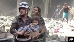 Petugas Pertahanan Sipil menggendong anak kecil menyusul serangan-serangan udara yang menghantam Aleppo, Suriah (28/4). 