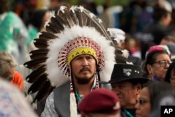 Indigenous people wait for Pope Francis during his visit to Maskwaci, the former Ermineskin Residential School, Monday, July 25, 2022, in Maskwacis, Alberta. Pope Francis traveled to Canada to apologize to Indigenous peoples for the abuses committed by Catholic missionaries in the country's notorious residential schools. (AP Photo/Eric Gay)