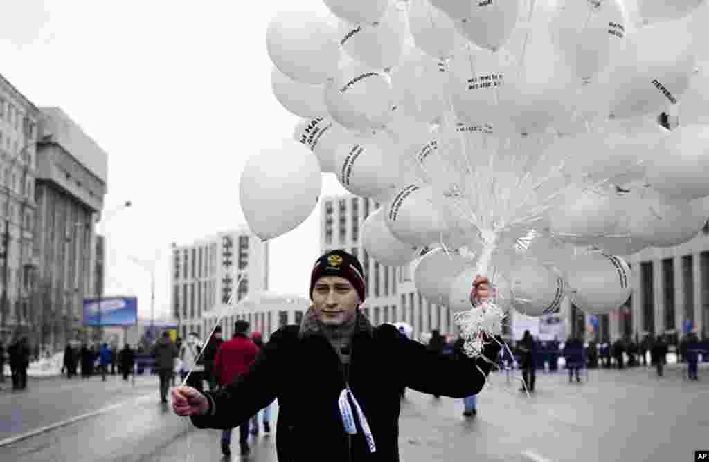 A protester hands out white balloons at the rally. The white balloons were a symbol of peaceful protests, December 24, 2011. (VOA - Y. Weeks)