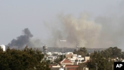 Smoke rises above buildings following a NATO air strike in Tripoli, Libya, April 14, 2011.