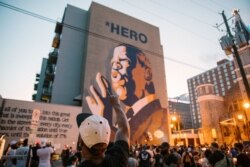 Personas realizan una vigilia frente a un edificio donde se encuentra una imagen del congresista John Lewis, en Atlanta, Georgia.