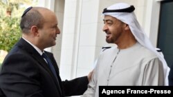 Foto yang dirilis oleh Kantor Media Israel menunjukkan Pangeran Abu Dhabi Sheikh Mohammed bin Zayed Al-Nahyan (kanan) menyambut kedatangan Perdana Menteri Israel Naftali Bennett, pada 13 Desember 2021. (Foto: GPO/AFP)