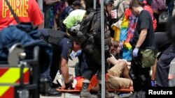 Rescue workers assist people who were injured when a car drove through a group of counter protestors at the "Unite the Right" rally Charlottesville, Virginia, Aug. 12, 2017. 