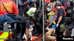 Para petugas penyelamat membantu korban luka saat sebuah mobil menabrak sekelompok demonstran dalam aksi protes di Charlottesville, Virginia, 12 Agustus 2017.