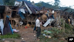 FILE - A man looks at homes destroyed by airstrikes in a refugee camp in Laiza, Myanmar, on Oct. 10, 2023. The attack killed at least 29 people, including children. Resistance leaders have blamed the ruling junta for the strikes, although the military denies involvement.