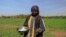 FILE - A farmer sprinkles fertilizer onto crops at a field on Tuti Island, Khartoum, Sudan, Feb. 12, 2020. The island in the middle of the Nile serves as a microcosm for the devastation unleashed by a war that began in April 2023.