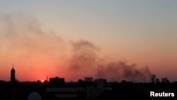 FILE - Black smoke billows in the sky above areas where clashes are taking place between pro-government forces, who are backed by the locals, and the Shura Council of Libyan Revolutionaries, an alliance of former anti-Gadhafi rebels, who have joined forces with the Islamist group Ansar al-Sharia in Benghazi, Libya, July 8, 2015.